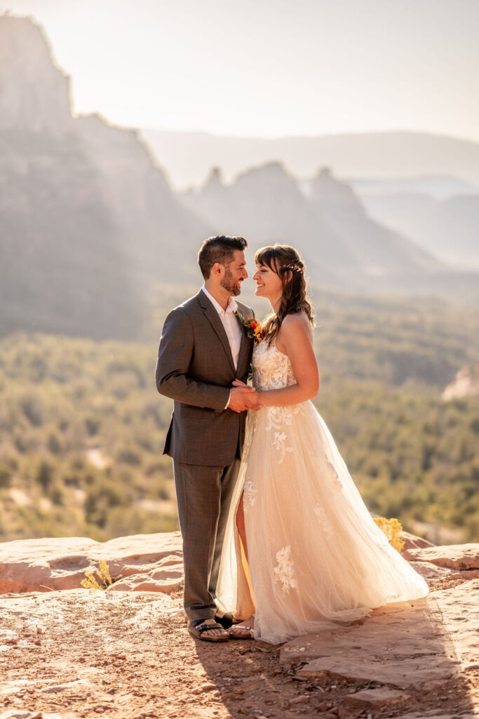 couple pose with red rock formations in the background