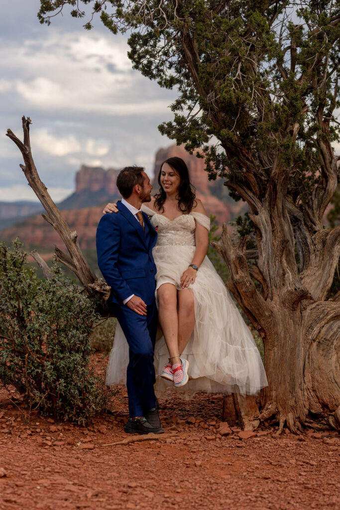 couple pose while sitting on tree branch