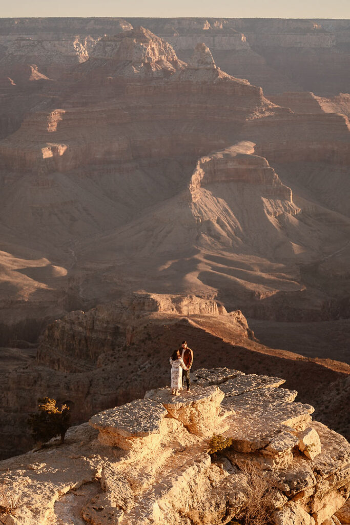 couple stands on overlook at Grand Canyon engagement session