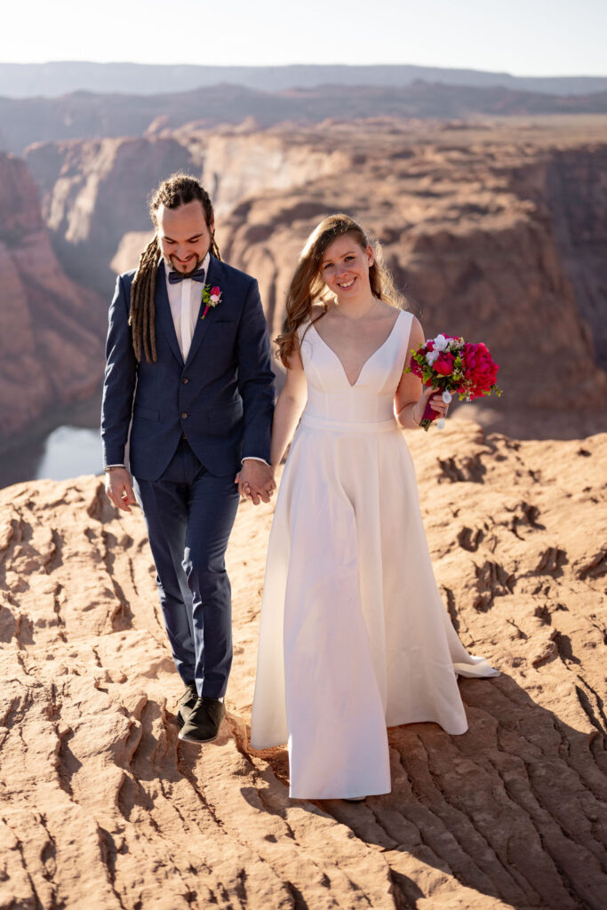 couple holds hands at horseshoe bend elopement