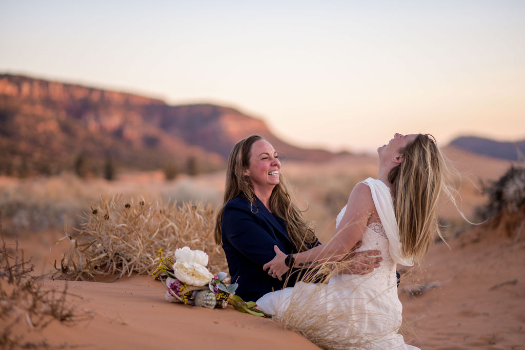 couple holds hands at Coral Pink Sand Dunes elopement