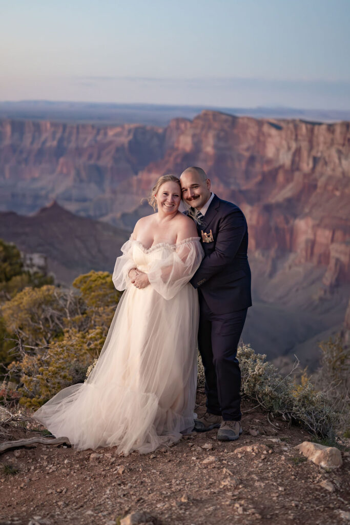 couple poses on rocky ledge during Grand Canyon elopement