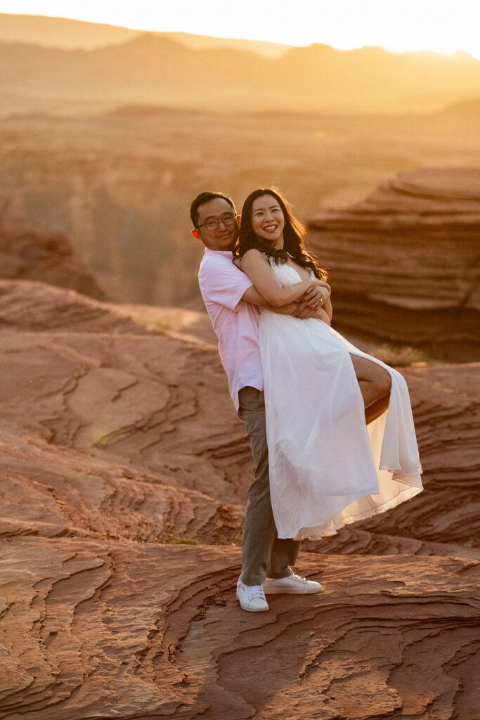 Couple pose at sunset on red rock cliffs