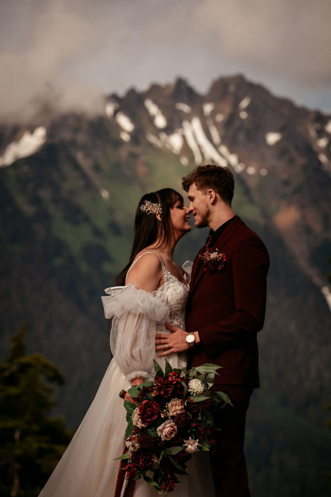 couple kiss in front of mountain landscape