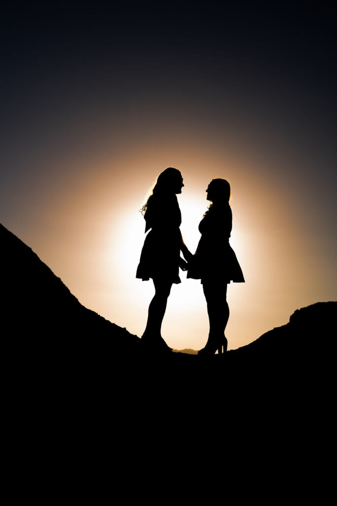 couple holds hands in sunset sillouette