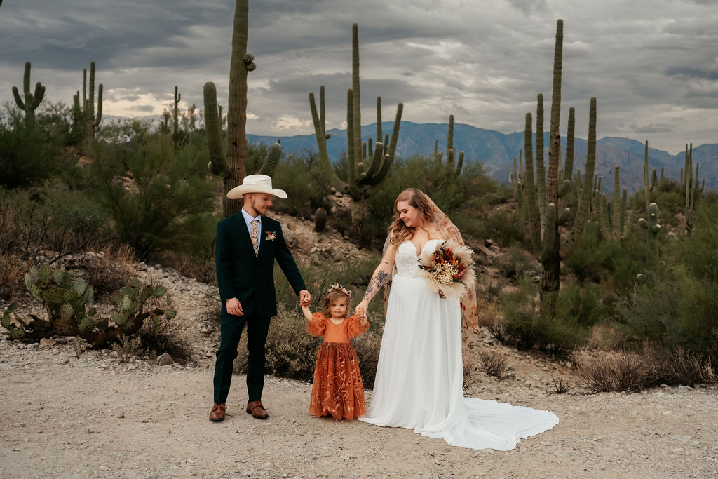 couple and daughter pose in front of cacti in Honey Bee Canyon Park