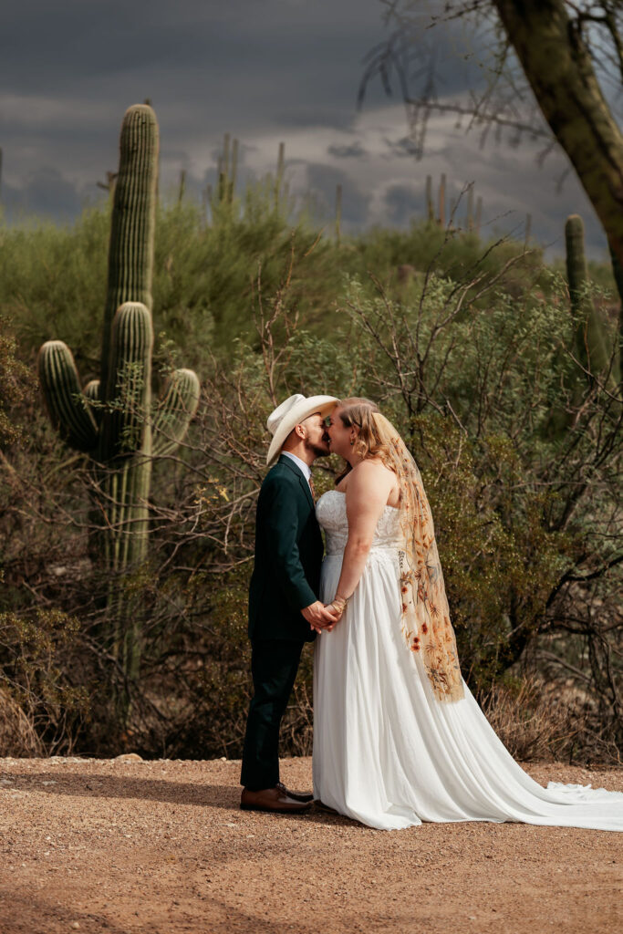 couple kiss in front of large cactus