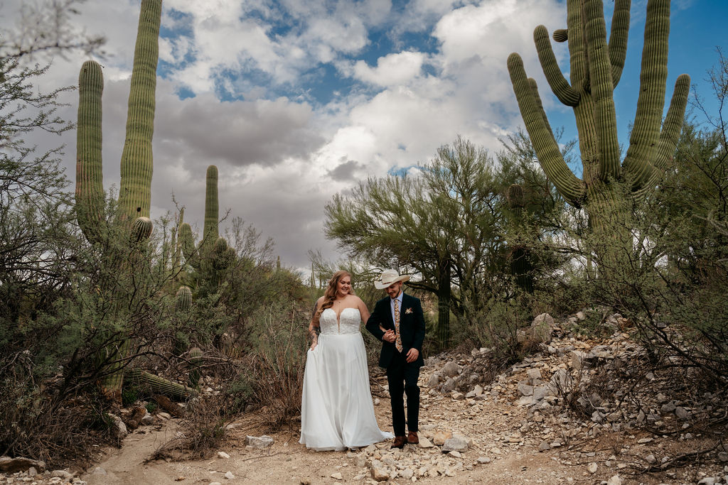 couple pose in front of desert landscape in Honey Bee Canyon Park