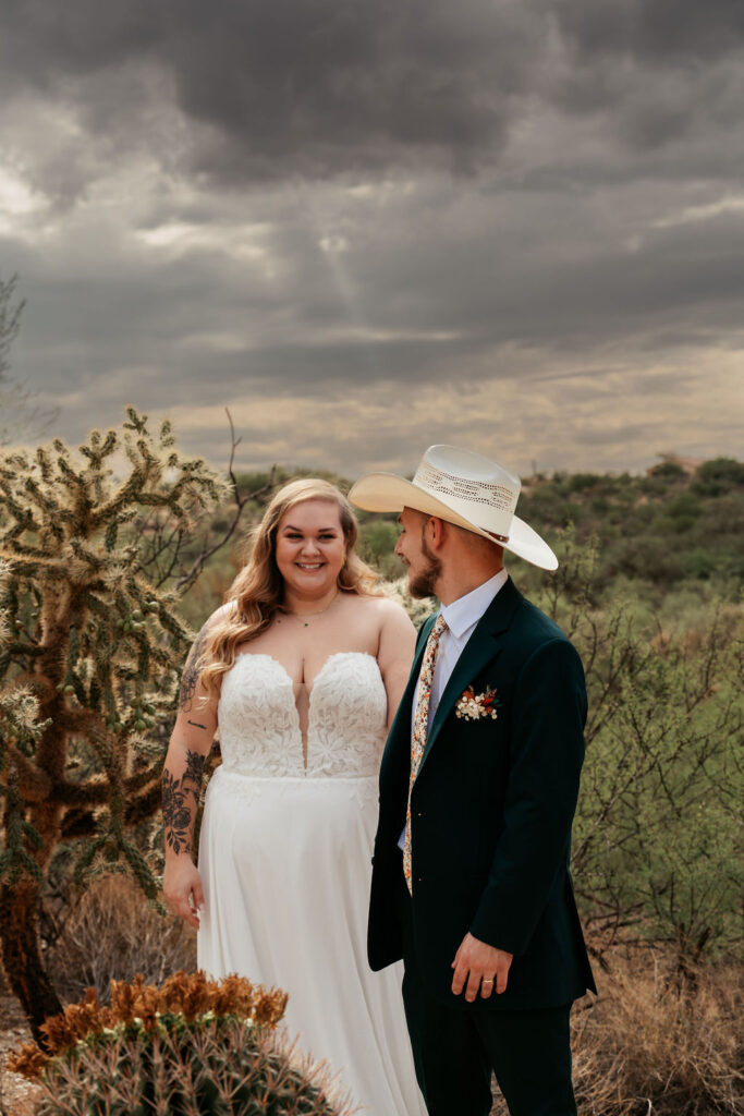 couple pose in front of desert landscape in Honey Bee Canyon Park