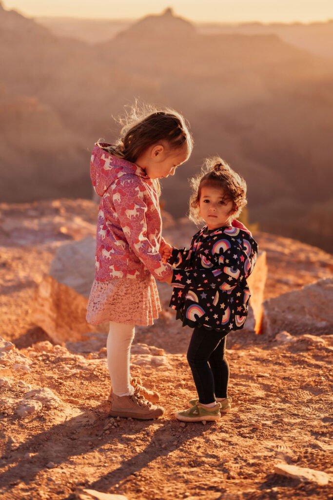 two little girls holding hands on rocky landscape
