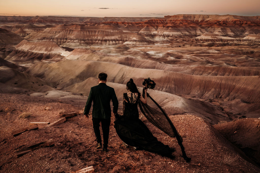 couple walking along path overlooking Arizona painted desert