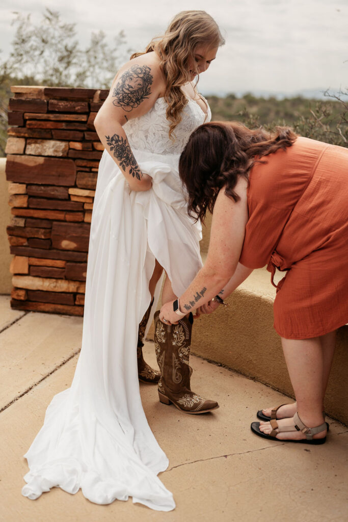 bridesmaid helping bride put on boots