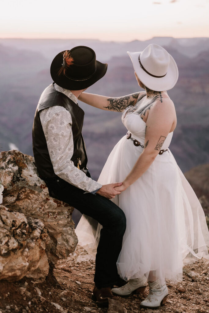 couple pose along rock overlooking Grand Canyon