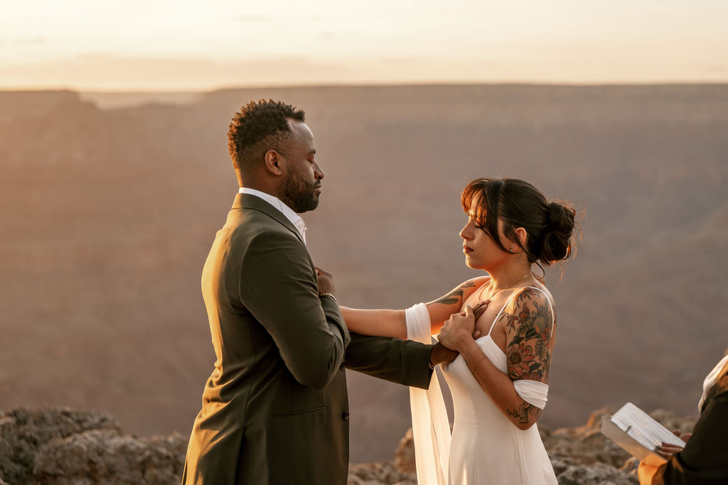 couple touch each other's heart during ceremony