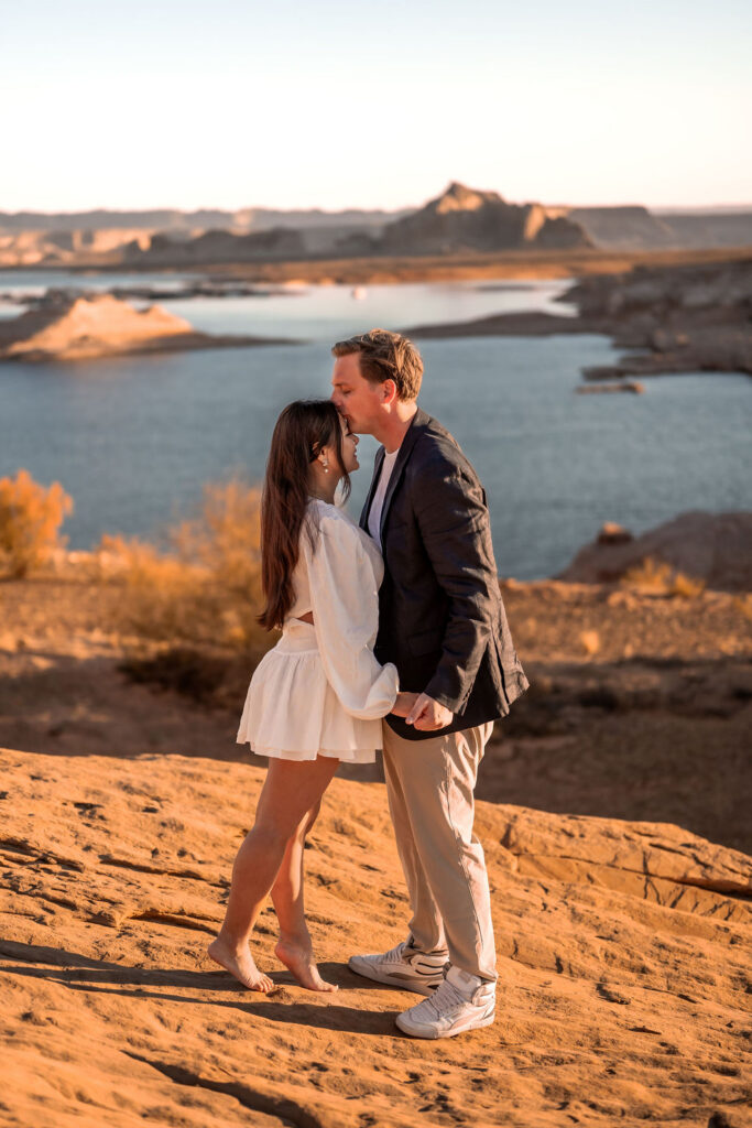 couple kiss in the sand by the water