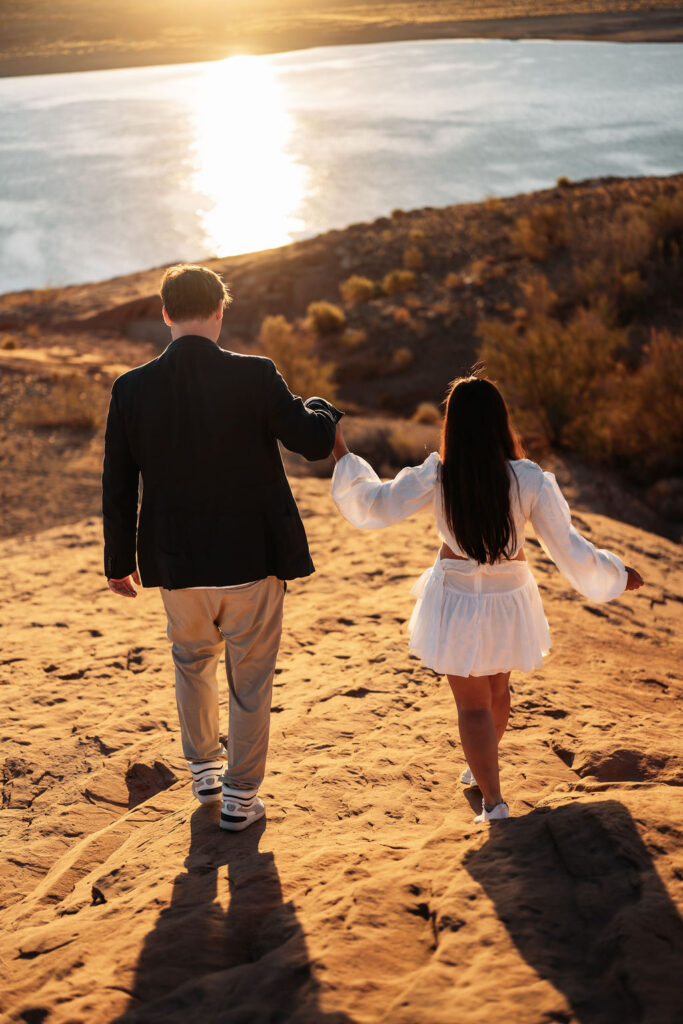 couple walking holding hands by the water