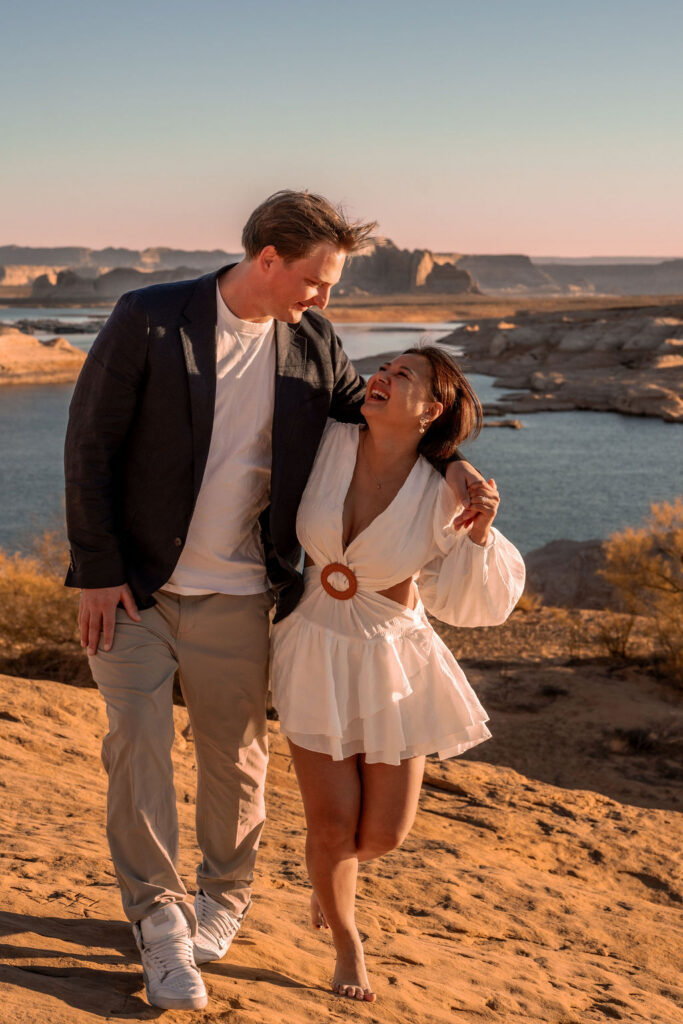 couple walking and laughing together by the water