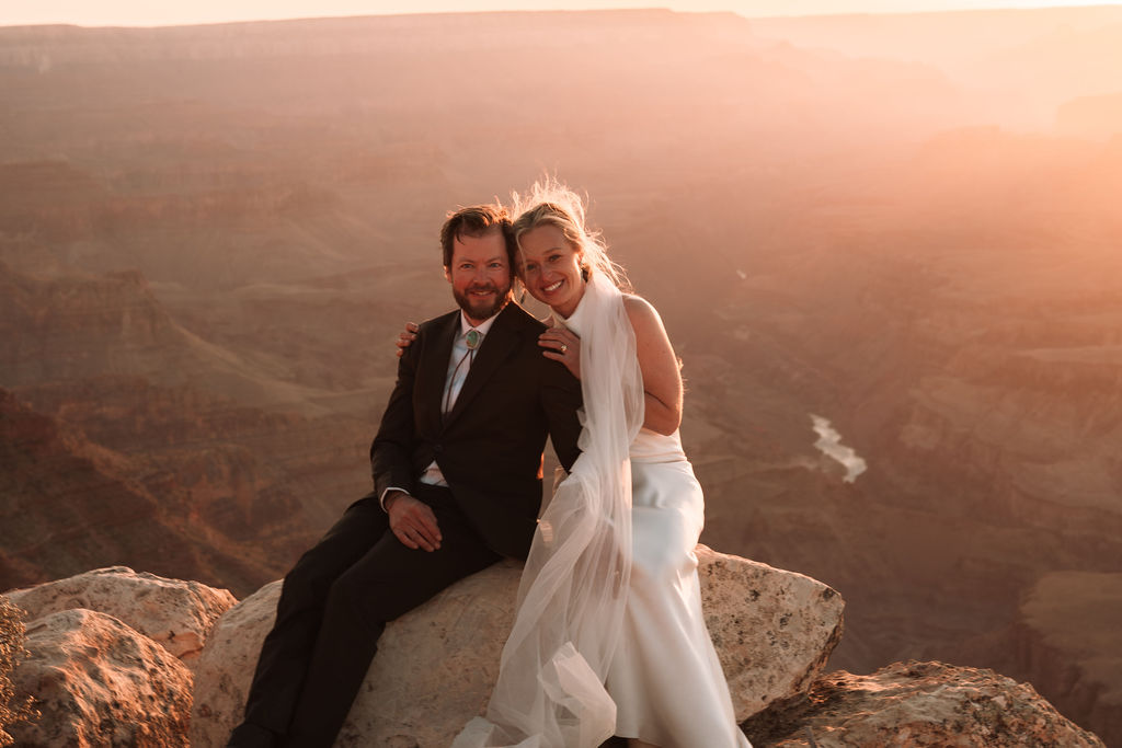 couple sitting on rock at sunset