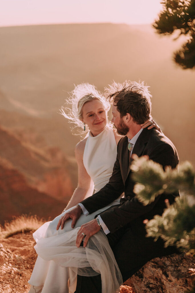 couple sits on overlook at Grand Canyon elopement