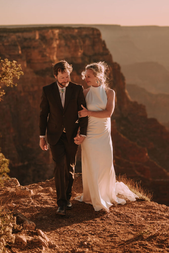couple walk along edge together as part of Grand Canyon adventure