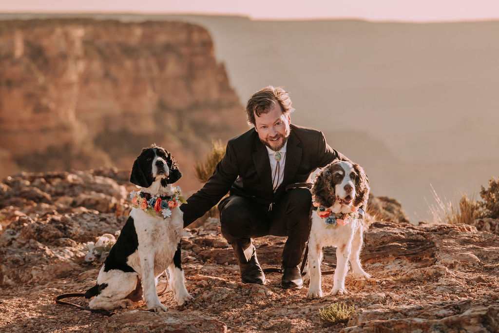 groom poses with dogs at Grand Canyon wedding