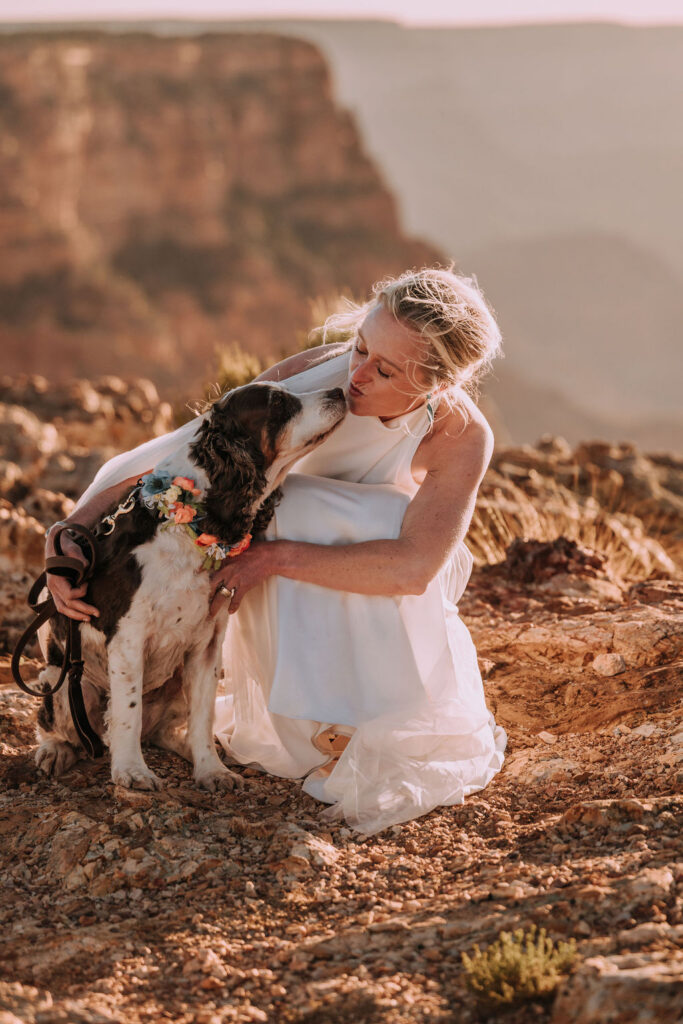 bride kisses dog with wedding bouquet