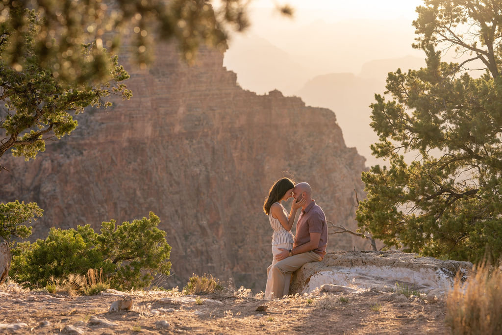 couple pose on rock during sunset