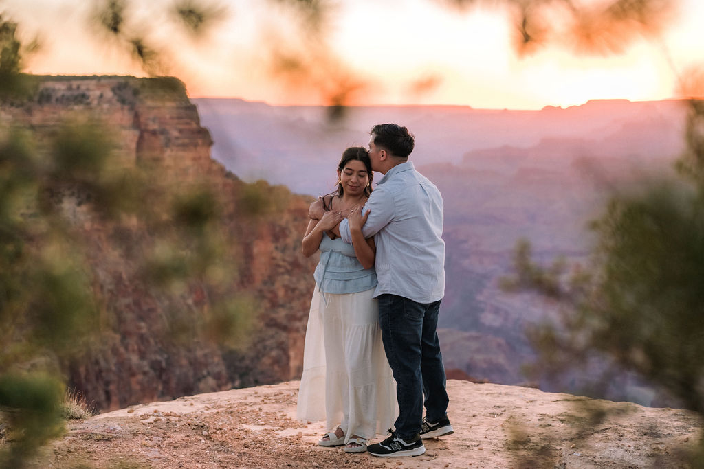 couple embrace and kiss at the Grand Canyon