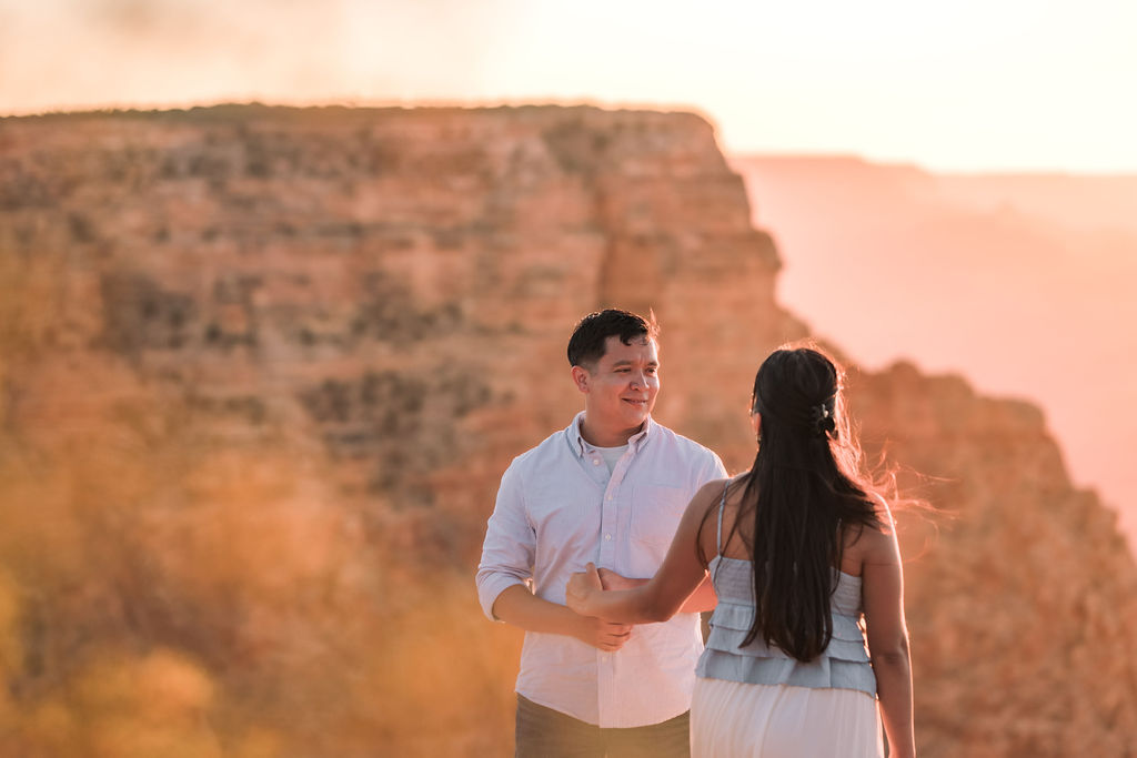 couple hold hands during sunset at the Grand Canyon