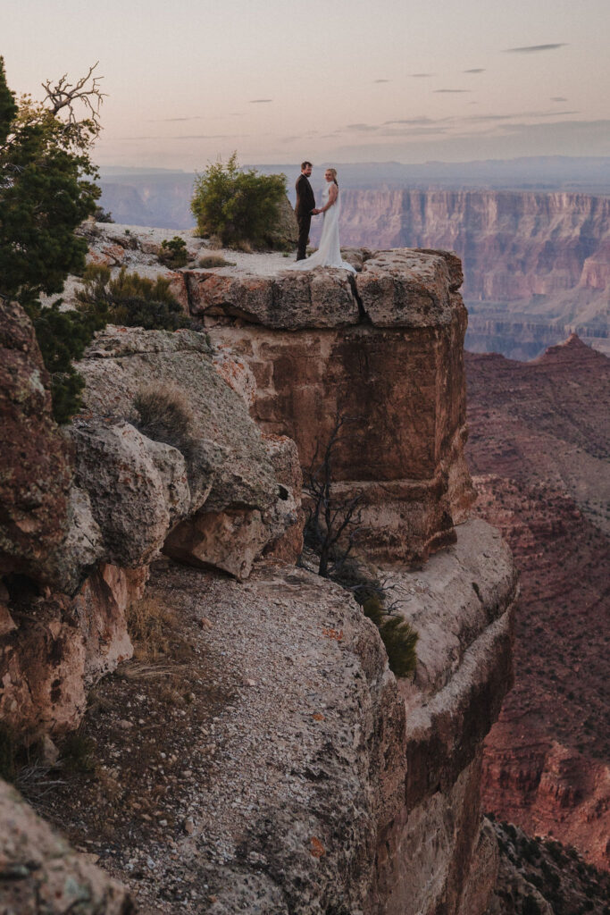couple stands on cliff at Grand Canyon elopement 