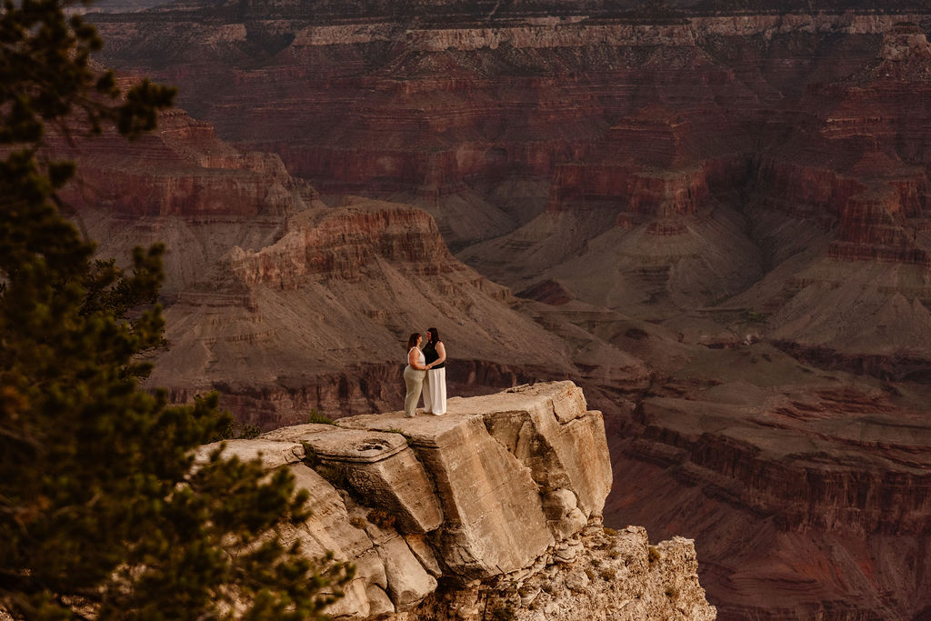 couple stands on overlook at Grand Canyon sunrise