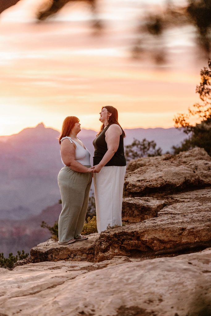 couple stands holding hands at sunrise